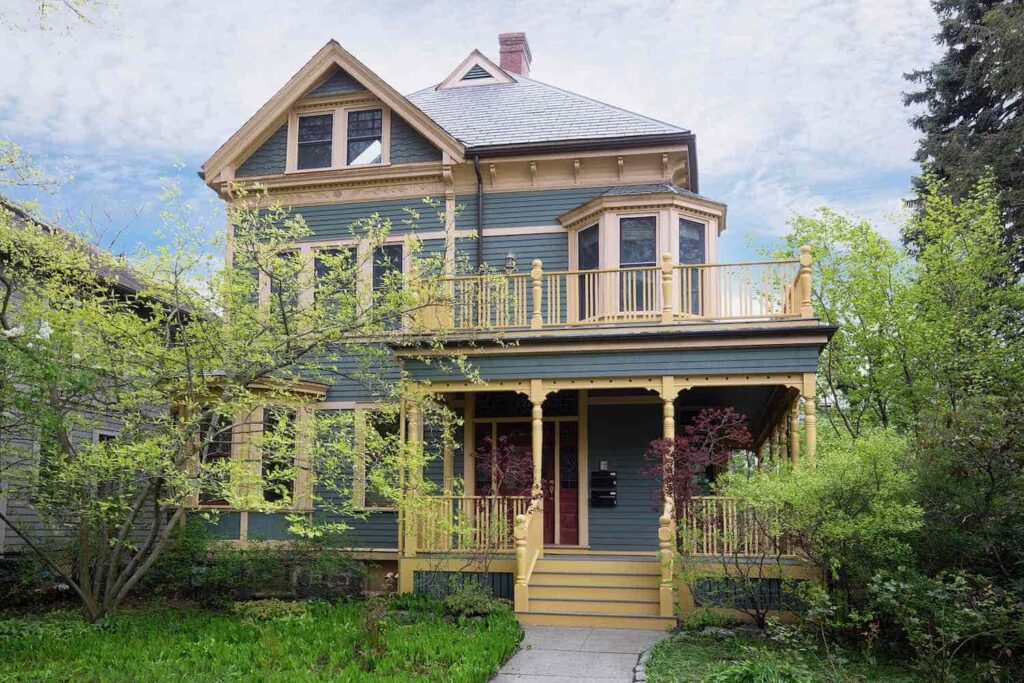 An image of Dark blue house featuring handcrafted cedar railings for a refined exterior.
