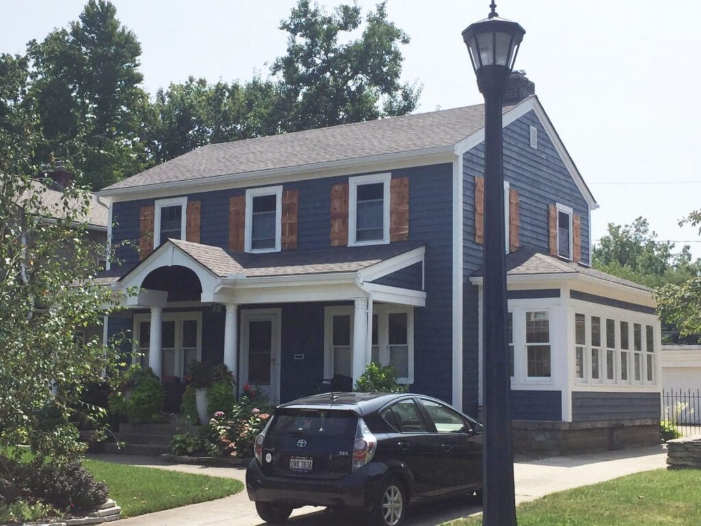 An image of Dark blue house with classic cedar shutters.