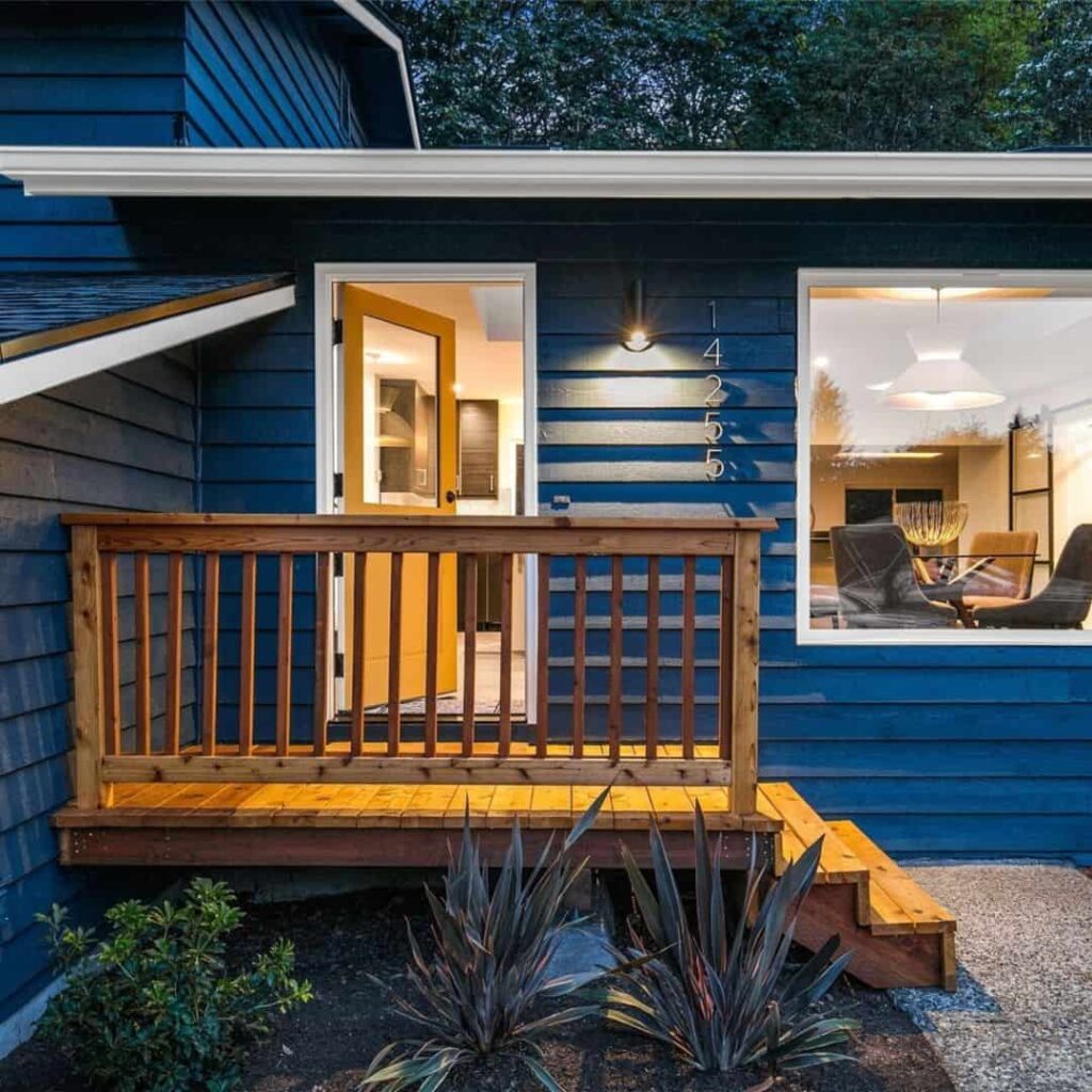 An image of Elegant dark blue house with a cedar staircase and natural wood finishes.